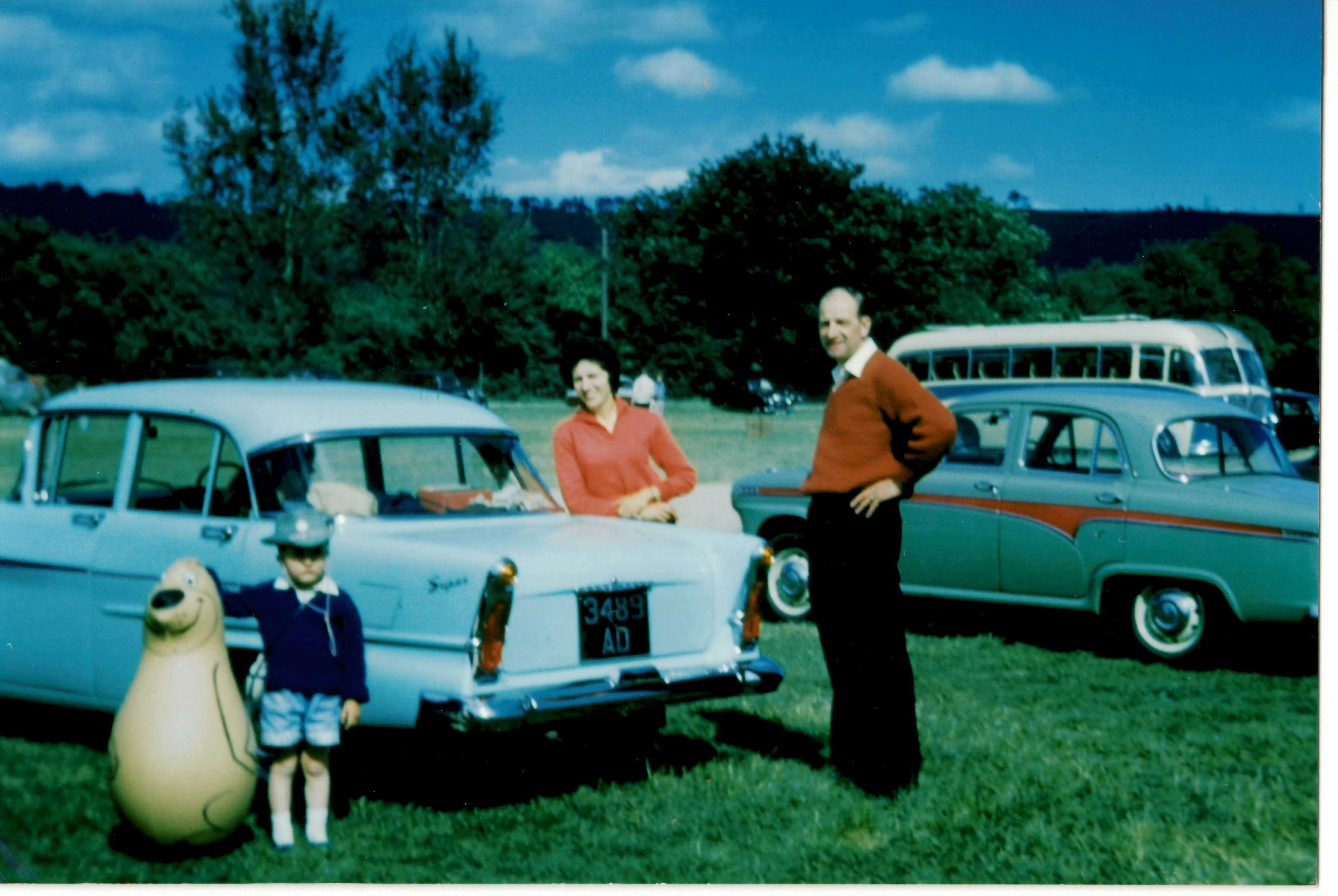 Family photo with two cars and a child.